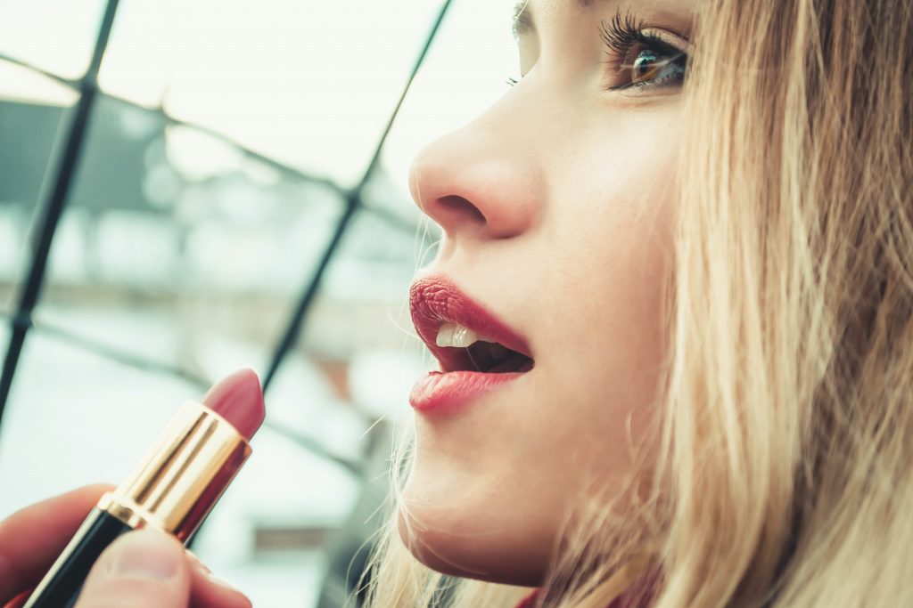 Woman with medium skin wearing lipstick. 